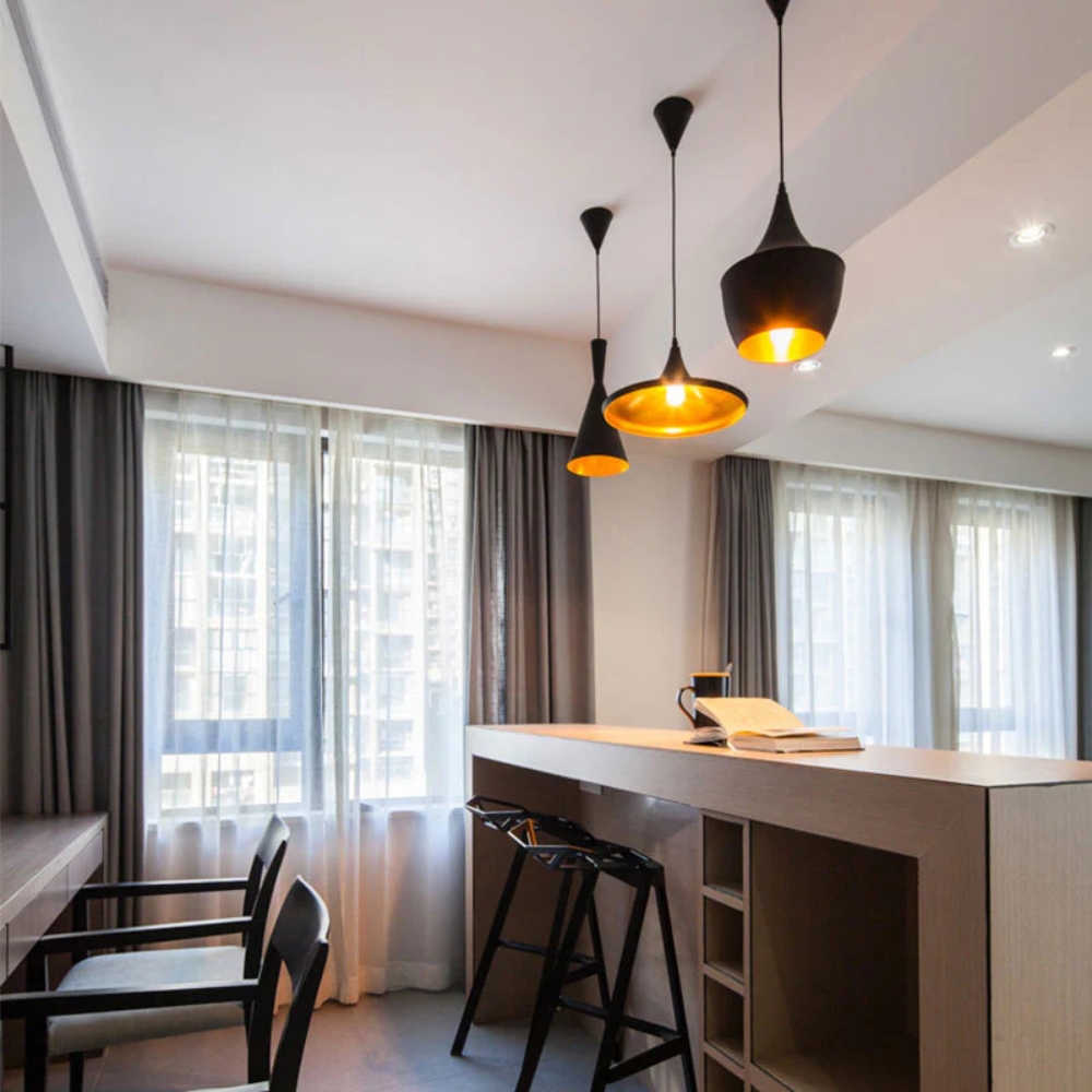 Vintage pendant lamps Style A, B, and C in black and gold hanging in a modern living room.